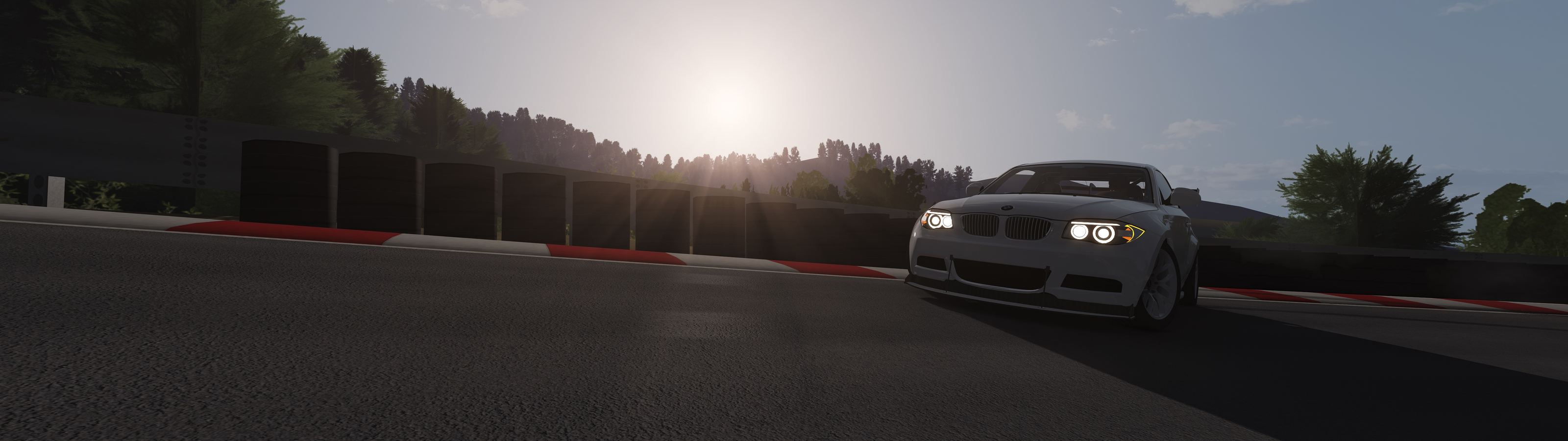 White BMW 1 Series on a mountain road at sunset, in Assetto Corsa